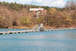 Schwimmende hölzerne Brücke und Übergang über azurblaues Seewasser in diagonaler Ausrichtung - Landschaftsaufnahme