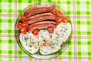 Scrambled egg with sausages and cherry tomatoes