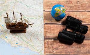 Segelschiff auf Landkarte und Fernglas mit Globus als Symbolbild für Reise und Abenteuer
