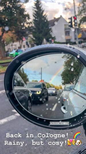 Seitenspiegel von Auto mit Regenbogen