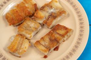 Served fried Alaska Pollock fish on the plate (Flip 2020)