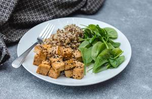 Sesam-Tofu und Quinoa mit Spinat, auf einem Teller