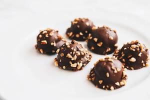 Set of chocolate candy with nuts on top. White background