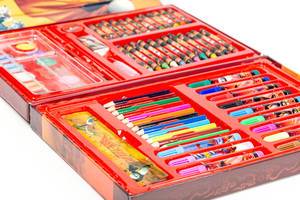 Set of colored pencils, felt-tip pens and paints in a red box