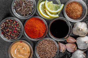 Set of different spices and sauces on a dark background