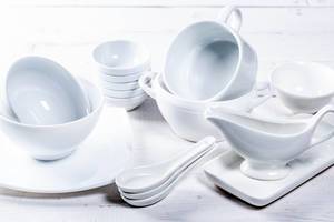Set of different white dishes on white background