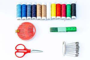 Sewing kits on white background with threads, needles and scissors