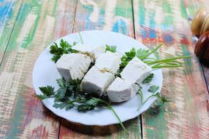 Sheep cheese and parsley on a white plate. Countryside wooden table (Flip 2019)