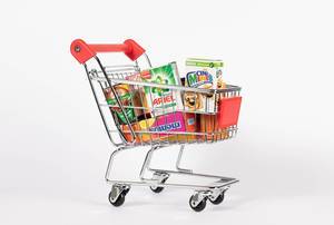 Shopping cart full of various groceries isolated on a white background