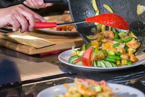 Shrimps-Pfanne: chinesisches Mittagessen mit Garnelen, Lauchzwiebeln, Tomaten und anderem frischen Gemüse