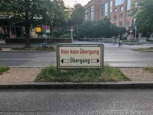 Sign with the text "No transition here" and with the indication of the right course on a street of Munich, Germany