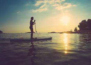 Silhouette of a woman on stand up paddle board