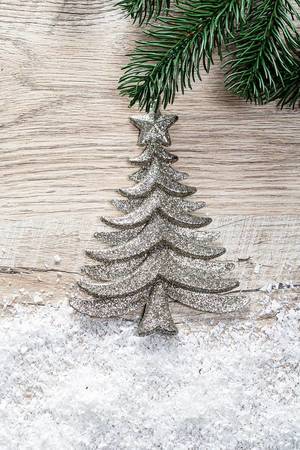 Silver Christmas tree with snow on a wooden background