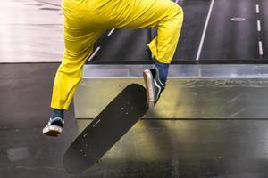 Skater mit gelben Hosen führt einen Trick auf dem Skateboard vor auf der Photokina in Köln