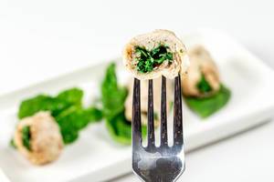 Slice of chicken roll with spinach on a fork close-up (Flip 2019)