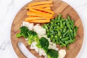 Sliced Carrot with Green Beans Onions and Broccoli on the wooden board