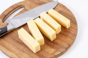 Sliced Cheddar Cheese on the kitchen wooden board (Flip 2019)