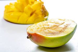 Sliced juicy ripe mango on white background (Flip 2019)