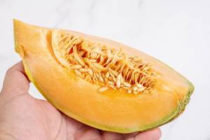 Sliced Melon in the hand above white background