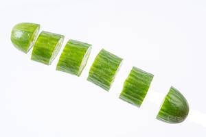 Sliced Mini Cucumber in the air above white background (Flip 2019)