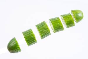 Sliced Mini Cucumber in the air above white background