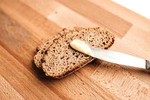 Slices of rye bread with butter on a wooden board