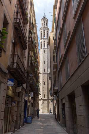 Small alley between mediterranean houses with view of the gothic church "Basílica de Santa Maria del Mar" in Barcelona, Spain