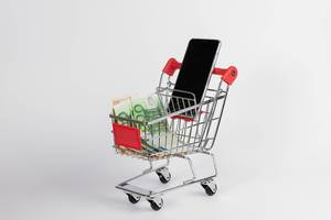 Smartphone with Euro banknotes in shopping cart