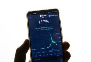 Smartphone zeigt Marktwert von Bitcoin an Aktienmarkt vor weißem Hintergrund