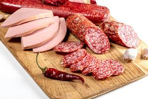 Smoked salami and sausage sliced on a wooden kitchen Board, close up