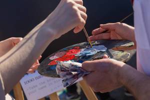 Soccer fans with paint brushes and paint in hands