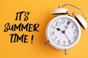 Sommer ist hier: Wecker mit dem Text ‘It’s summer time!’ vor gelbem Hintergrund