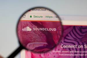 Soundcloud-Logo am PC-Monitor, durch eine Lupe fotografiert