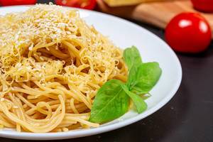Spaghetti with grated cheese and sesame seeds close-up