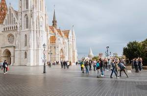 Spazierenden und fotografierenden Leuten vor der Matthiaskirche in Budapester Burgviertel