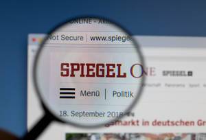 Spiegel Online Logo am PC-Monitor, durch eine Lupe fotografiert