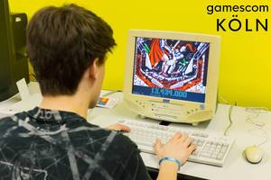 Spielemesse-Besucher spielt Vintagegames auf einem alten Computerbildschirm auf der Gamescom in Köln