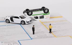 Spielzeug-Autounfall mit Versicherungsunterlagen für die Schadenmeldung