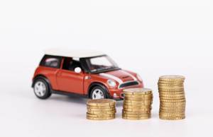 Spielzeugauto und Euros vor weißem Hintergrund