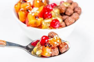 Spoon with chocolate corn balls and fruit slices