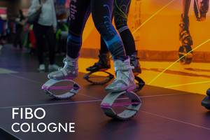 Sports fair visitors test Kargo Jumps with futuristic looking jumping shoes for fitness training, next to the picture title "Fibo Cologne"