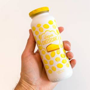 Spring Smoothie "Lemon Cheesecake" by German brand True Fruits, gently pasteurized and vegan, in a glass bottle held by a mans hand