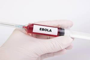 Spritze mit Injektionsnadel und dem Text Ebola