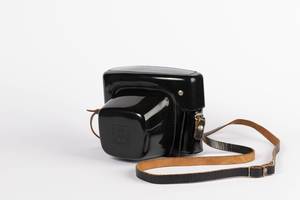 Stabile, schwarze Vintage-Kamerabox mit Lederriemen vor weißem Hintergrund