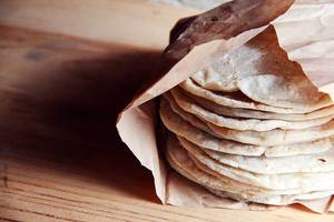 Stack of handmade Guatemalan and thick corn tortillas on a wooden table