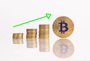 Stapel aus goldenen Münzen und Pfeil und goldener Bitcoinmünze