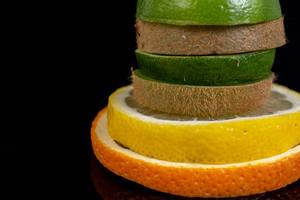 Stapel von Obst- und Zitrusfruchtscheiben: Orange, Limone, Limette und Kiwi