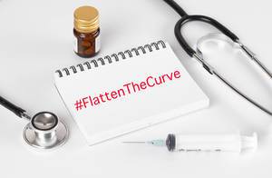 Stethoscope with notebook and syrige and #FlattenTheCurve text