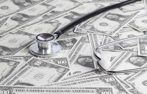 Stethoskop liegt auf verteilten Dollarnoten – wie gesund ist die Wirtschaft