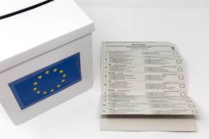 Stimmzettel der Briefwahlunterlagen für die Europawahl, mit einer Liste der teilnehmenden Parteien aus Deutschland, neben einer EU-Wahlurne